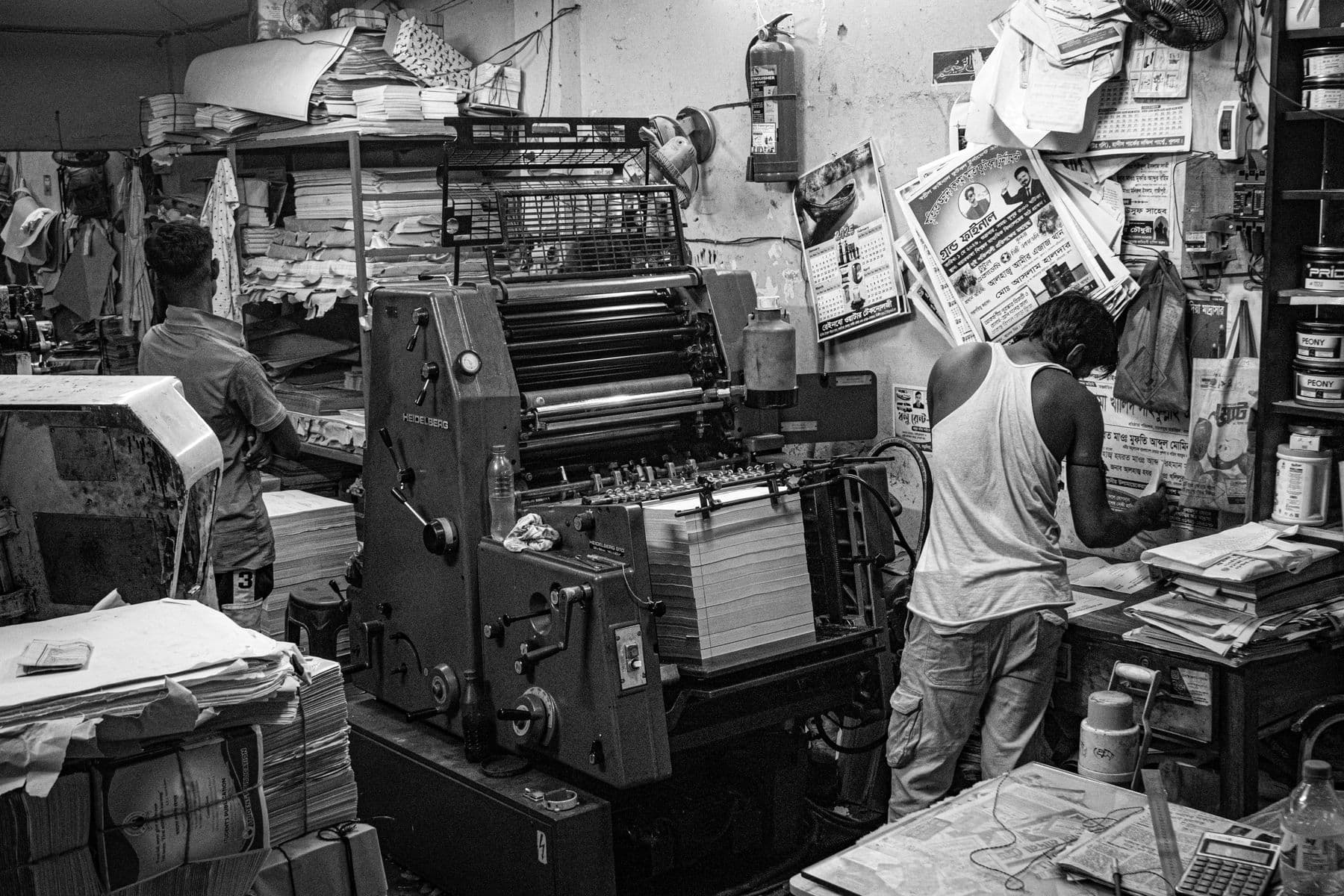 The floor of a working offset print shop with operators at the press