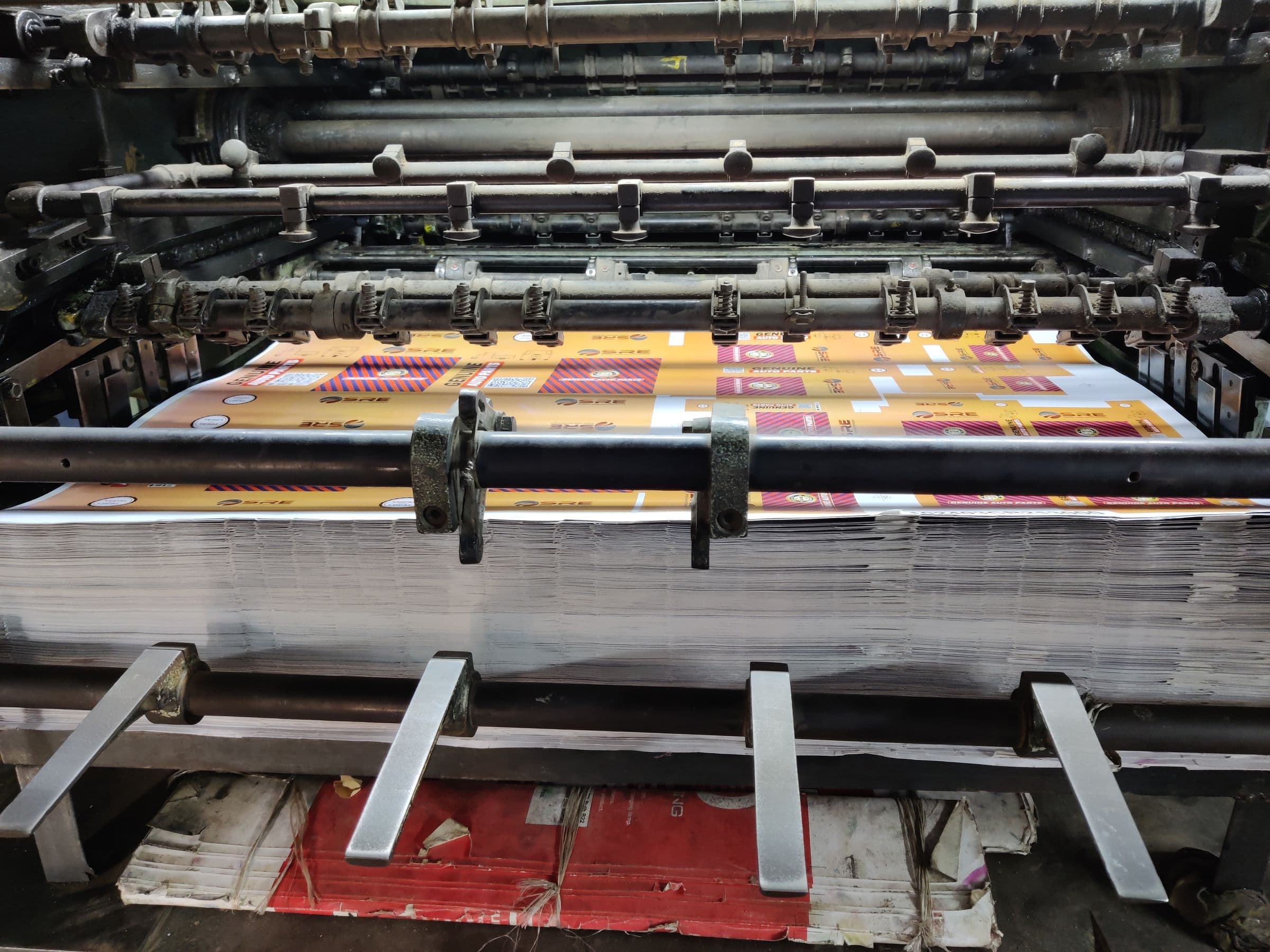 Freshly printed multicolour sheets stacked at the delivery end of an offset press